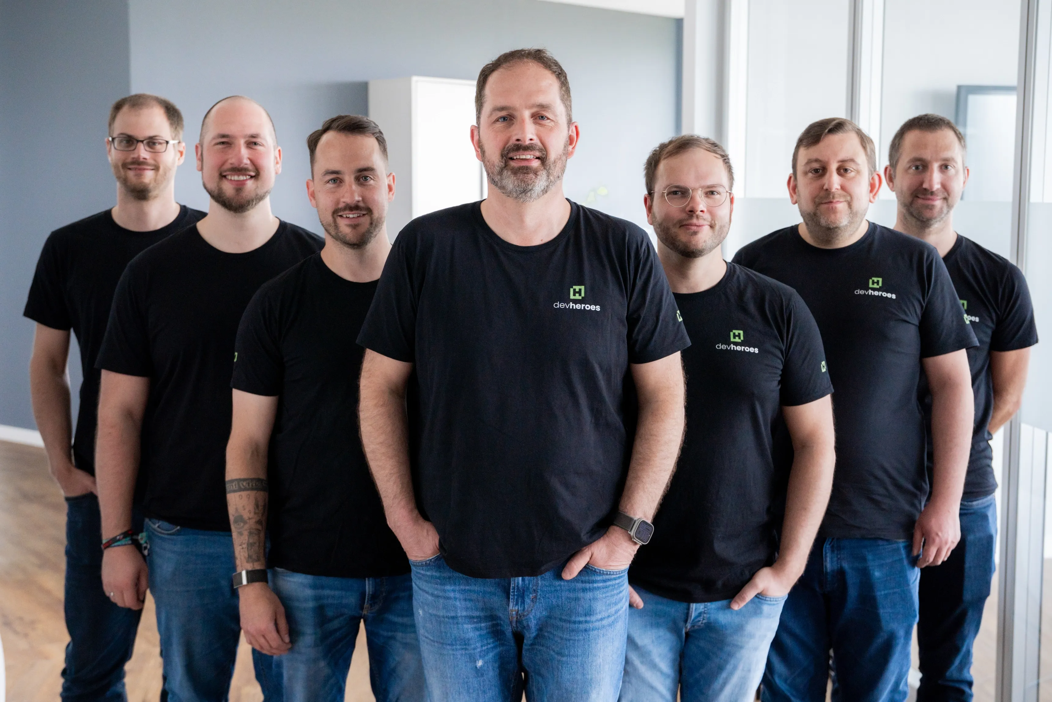 Eine Collage aus Bildern von gelücklichen devheroes Entwicklern bei der Arbeit.